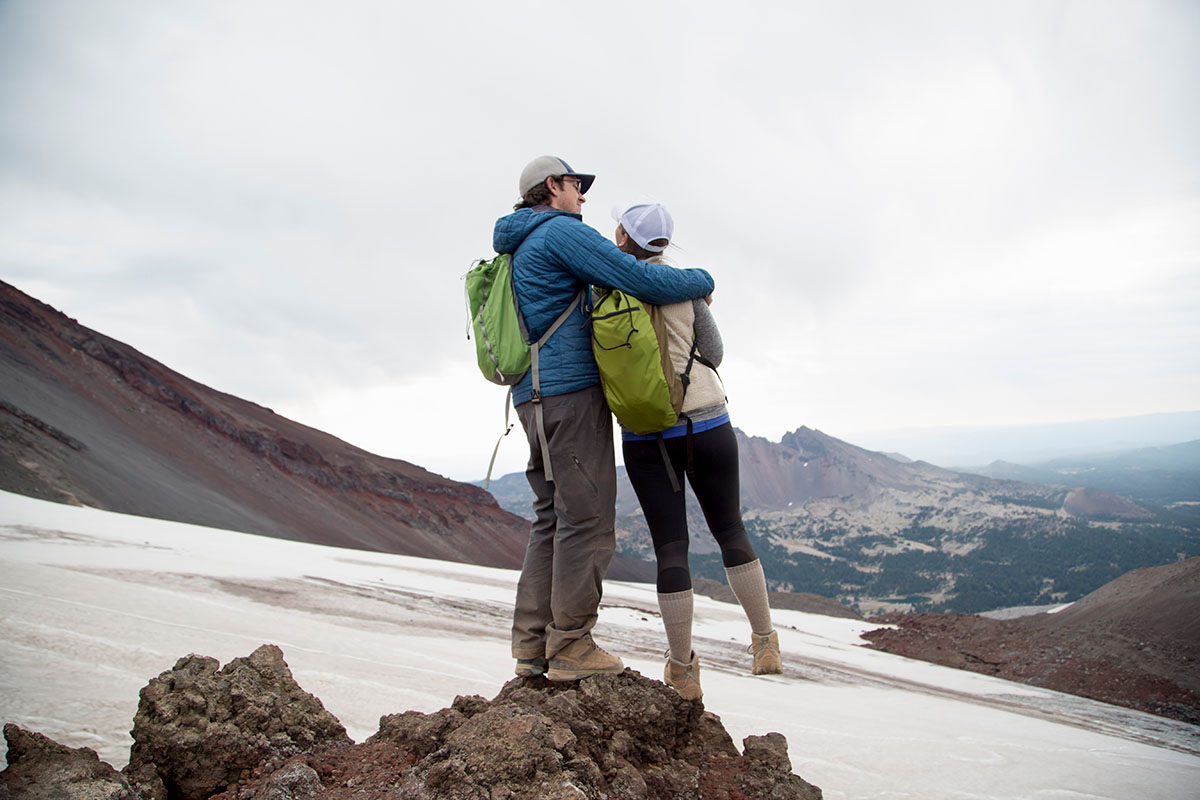 young couple standing at the summit of south-sister