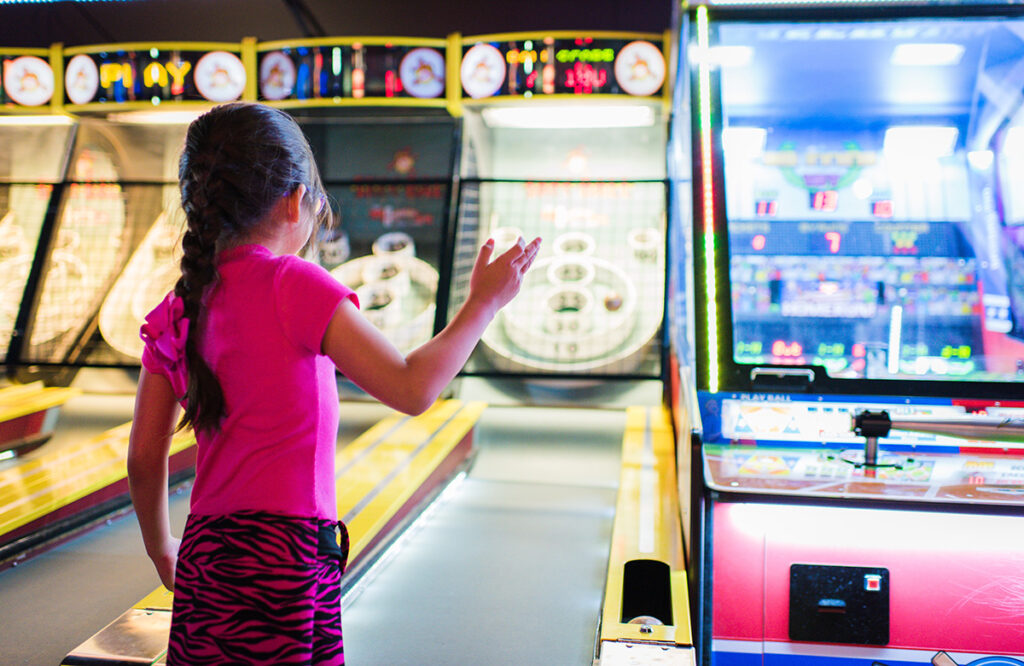 Girl playing ski-ball at arcade